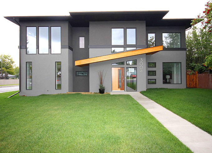 Exemple d'une façade de maison grise tendance en stuc de taille moyenne et à un étage.