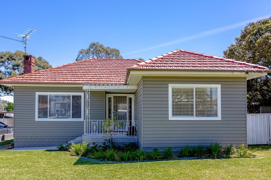 Ejemplo de fachada de casa gris y roja vintage de tamaño medio con revestimiento de madera, tejado a cuatro aguas, tejado de teja de barro y tablilla