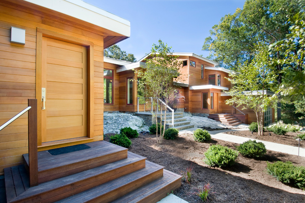 Inspiration for a large modern brown two-story wood house exterior remodel in Boston with a hip roof and a metal roof