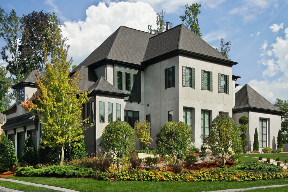 Large trendy gray two-story stucco gable roof photo in Charlotte