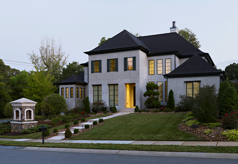 Идея дизайна: большой, двухэтажный, серый дом в современном стиле с облицовкой из цементной штукатурки и двускатной крышей