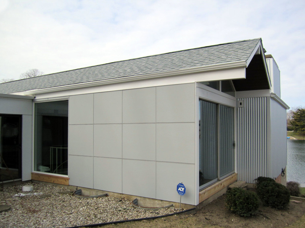 Cette photo montre une très grande façade de maison grise tendance en panneau de béton fibré de plain-pied avec un toit à deux pans.