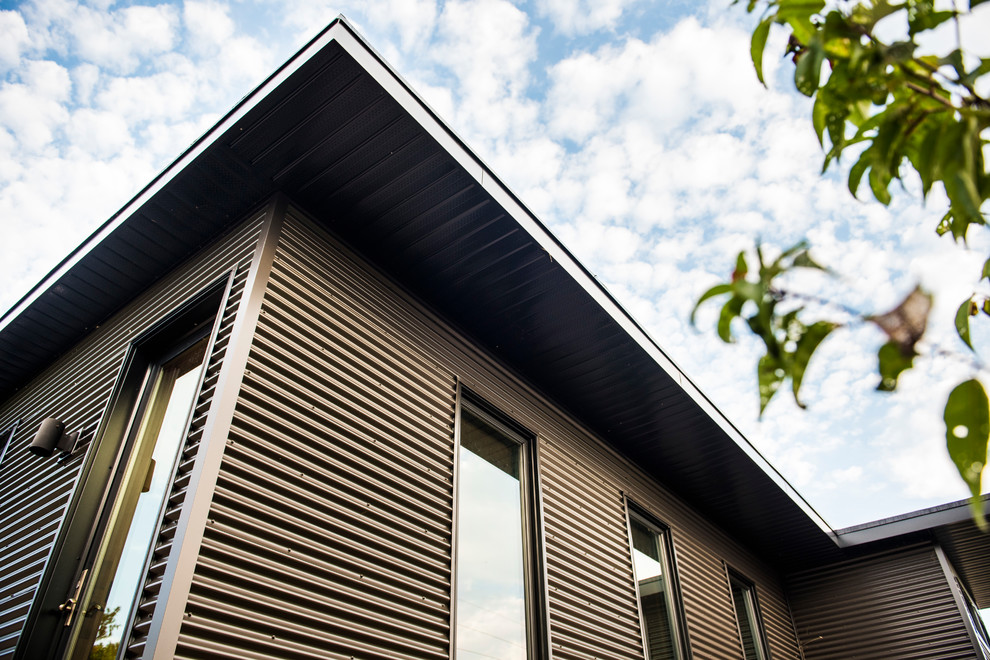 Kleines, Einstöckiges Country Einfamilienhaus mit Metallfassade, grauer Fassadenfarbe, Flachdach und Blechdach in Toronto