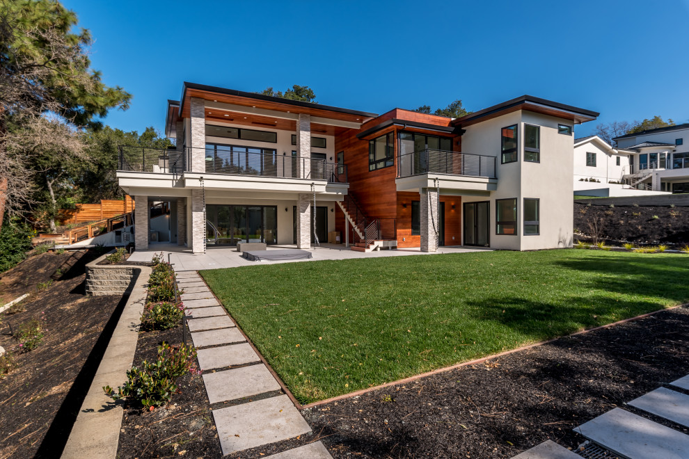 Imagen de fachada de casa gris minimalista grande de dos plantas con revestimiento de madera, tejado plano y techo verde