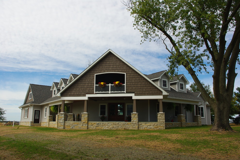 На фото: двухэтажный, серый дом среднего размера в стиле кантри с облицовкой из винила и двускатной крышей