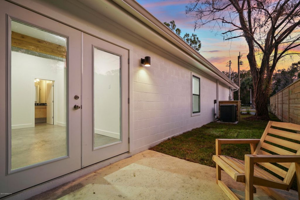 Idee per la facciata di una casa bianca moderna a un piano di medie dimensioni con rivestimento in mattone verniciato e copertura in metallo o lamiera