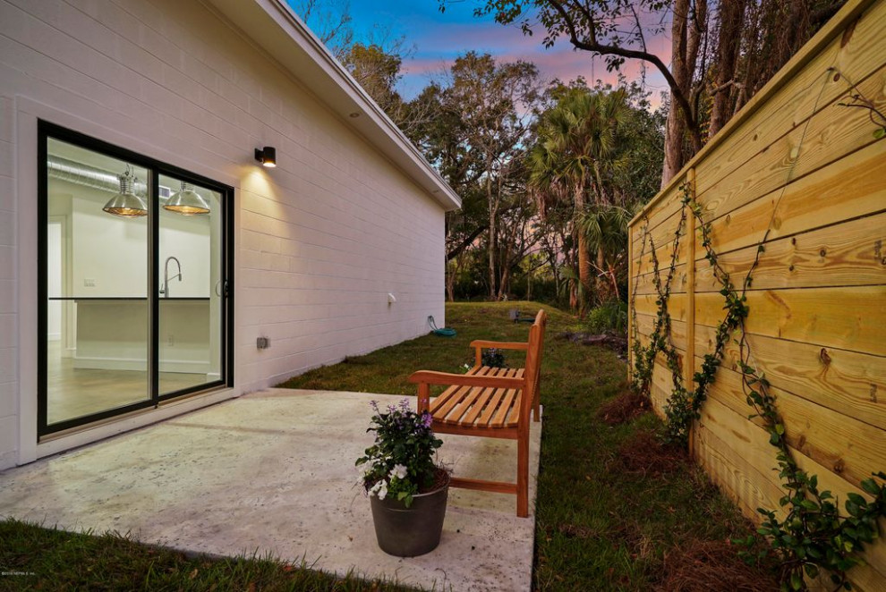 Diseño de fachada de casa blanca minimalista de tamaño medio de una planta con ladrillo pintado, tejado de un solo tendido y tejado de metal