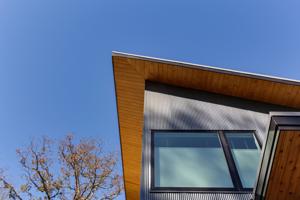 Inspiration för mellanstora moderna grå hus, med två våningar, metallfasad och pulpettak