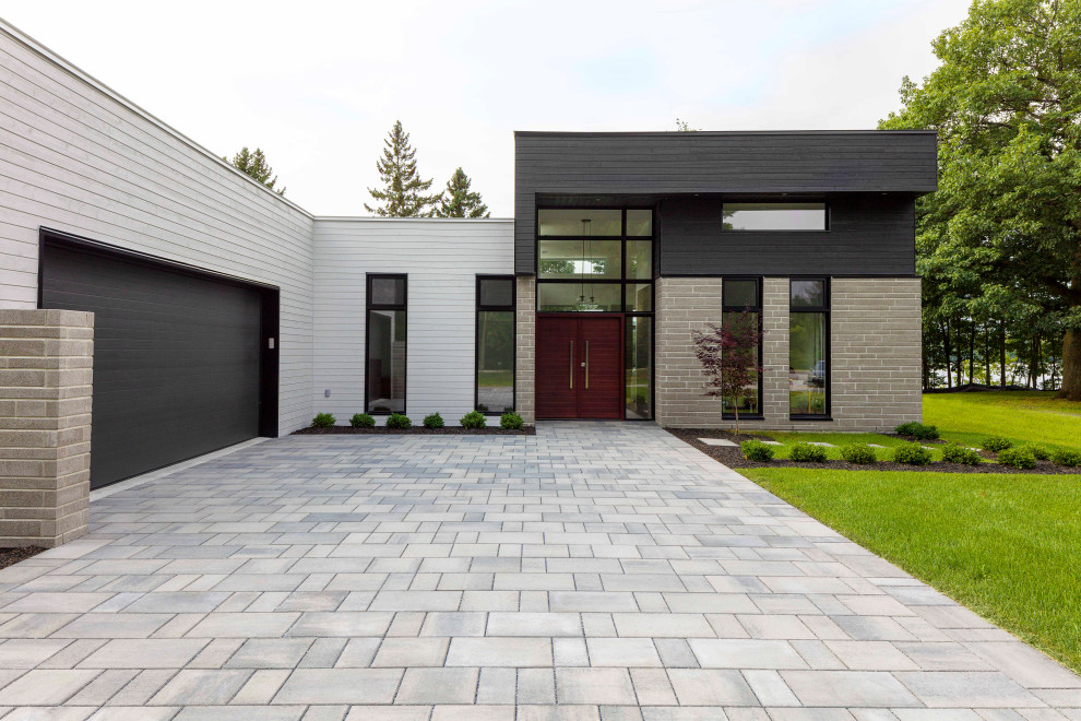 Réalisation d'une façade de maison multicolore minimaliste de plain-pied avec un revêtement mixte et un toit plat.