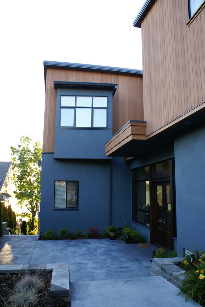 Exempel på ett stort modernt blått trähus, med tre eller fler plan