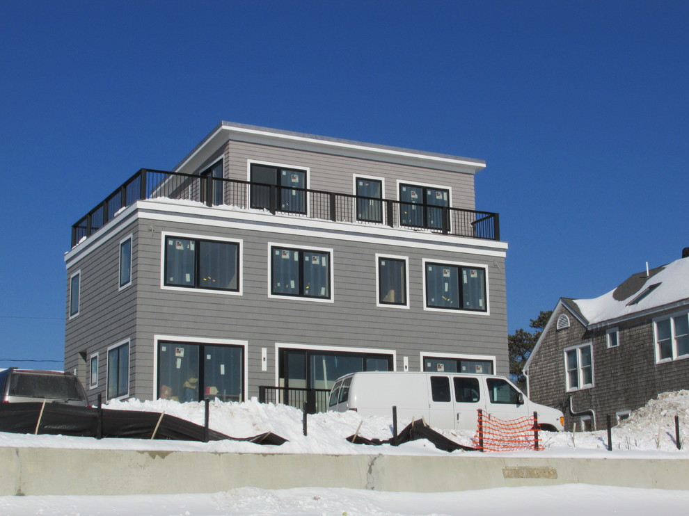 Inspiration for a modern gray three-story vinyl flat roof remodel in Portland Maine