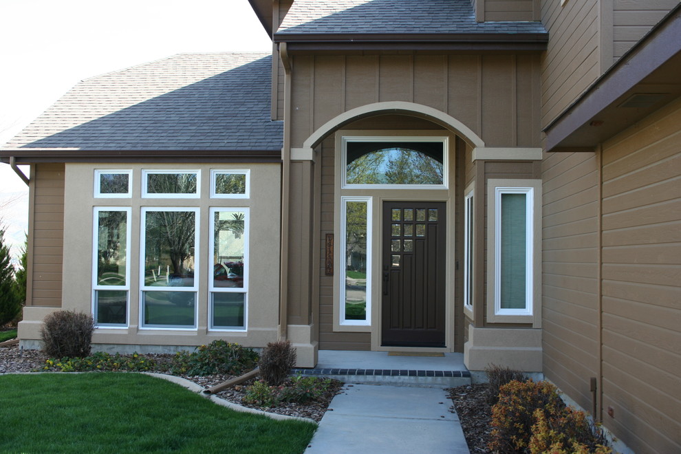Photo of a large and brown traditional two floor house exterior in Boise with concrete fibreboard cladding and a half-hip roof.