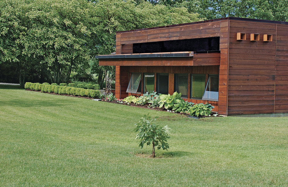 Ejemplo de fachada de casa marrón minimalista de tamaño medio de una planta con revestimiento de madera y tejado plano