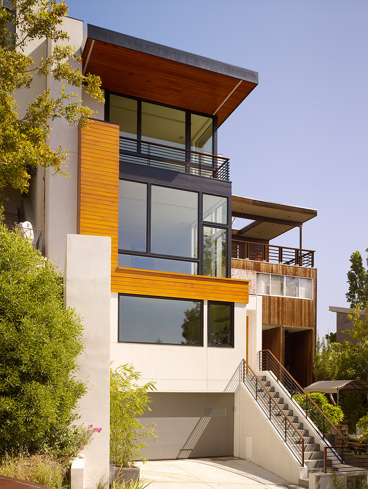 На фото: дом в стиле модернизм с облицовкой из цементной штукатурки с