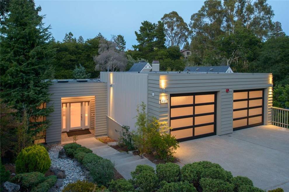 Inspiration pour une façade de maison beige minimaliste à niveaux décalés et de taille moyenne avec un toit plat et un revêtement mixte.