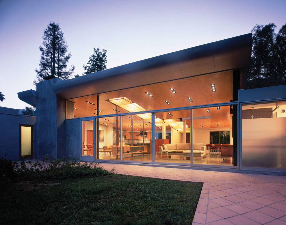 Ejemplo de fachada gris minimalista de tamaño medio de una planta con revestimiento de estuco y tejado de un solo tendido