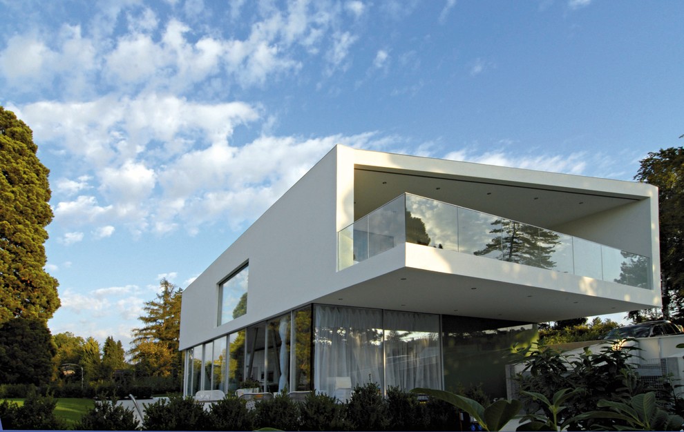 Modelo de fachada blanca actual de tamaño medio de dos plantas con revestimientos combinados