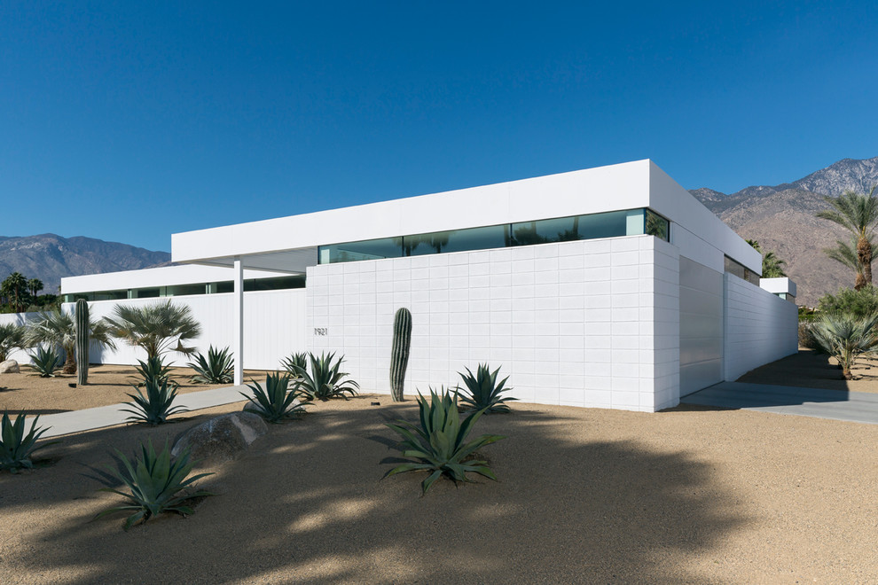 На фото: одноэтажный, белый дом в стиле модернизм с плоской крышей