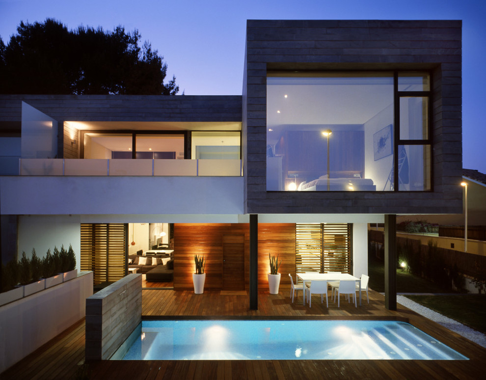 Cette image montre une façade de maison minimaliste en bois à un étage avec un toit plat.