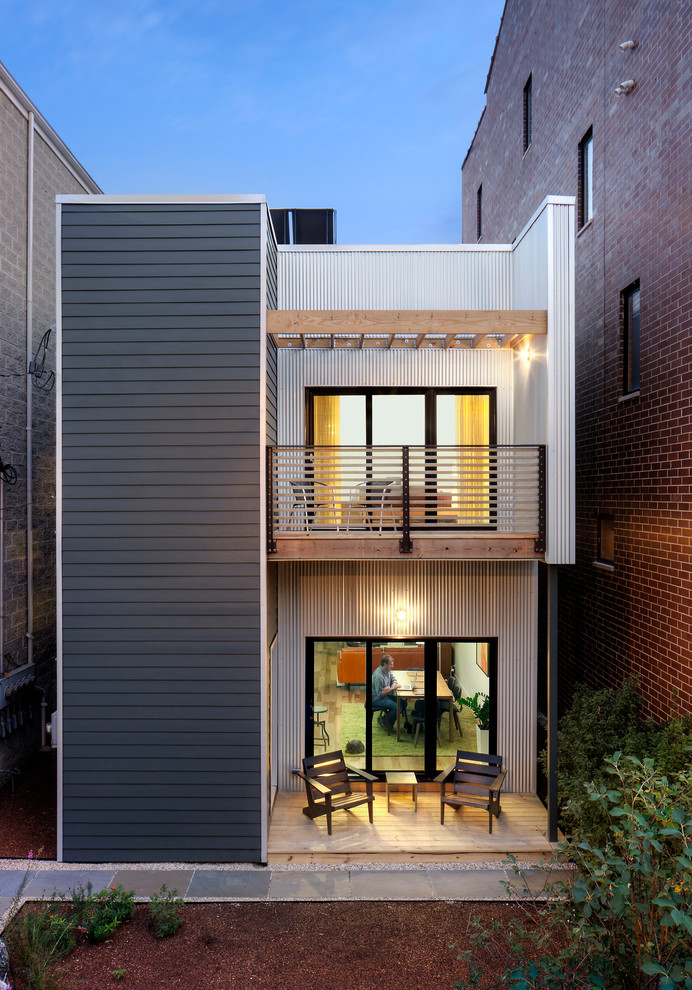Imagen de fachada gris minimalista de dos plantas con revestimientos combinados