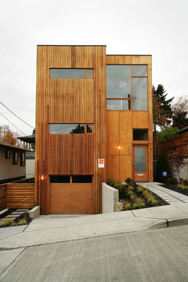 Foto della facciata di una casa moderna con rivestimento in legno e terreno in pendenza