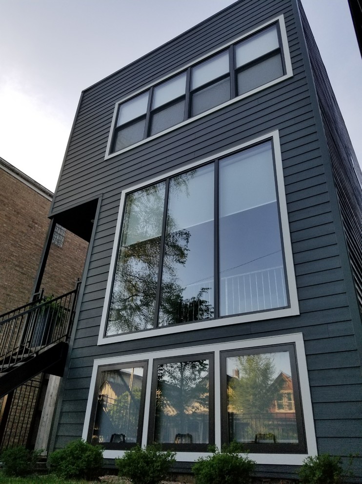 Inspiration för ett mellanstort funkis grått hus, med två våningar, fiberplattor i betong och platt tak