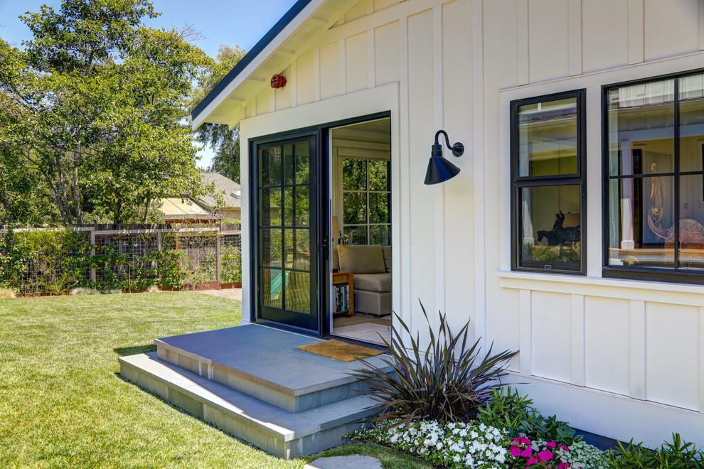 Photo of a small and white country bungalow detached house in San Francisco with wood cladding, a hip roof and a metal roof.