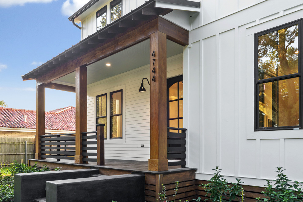 Diseño de fachada de casa blanca de estilo de casa de campo grande de dos plantas con revestimientos combinados, tejado a dos aguas y tejado de varios materiales