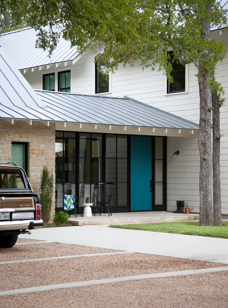 This is an example of a farmhouse two floor house exterior in Austin with mixed cladding and a metal roof.