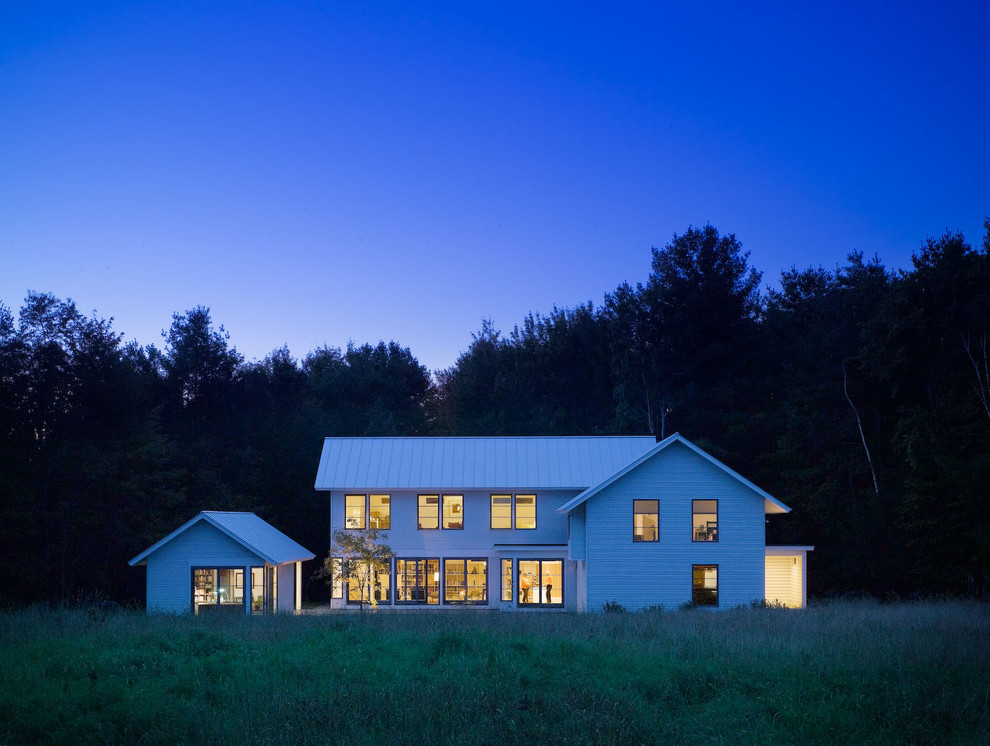 Cette image montre une façade de maison blanche rustique en bois à un étage avec un toit à deux pans.