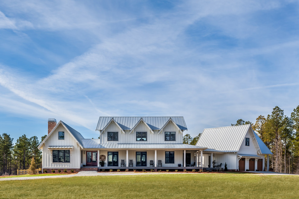 Foto della villa bianca country a due piani con tetto a capanna e copertura in metallo o lamiera