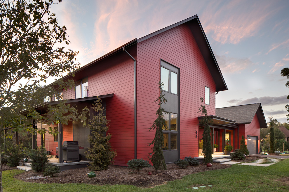 Mittelgroßes, Zweistöckiges Modernes Einfamilienhaus mit Faserzement-Fassade, roter Fassadenfarbe, Satteldach und Schindeldach