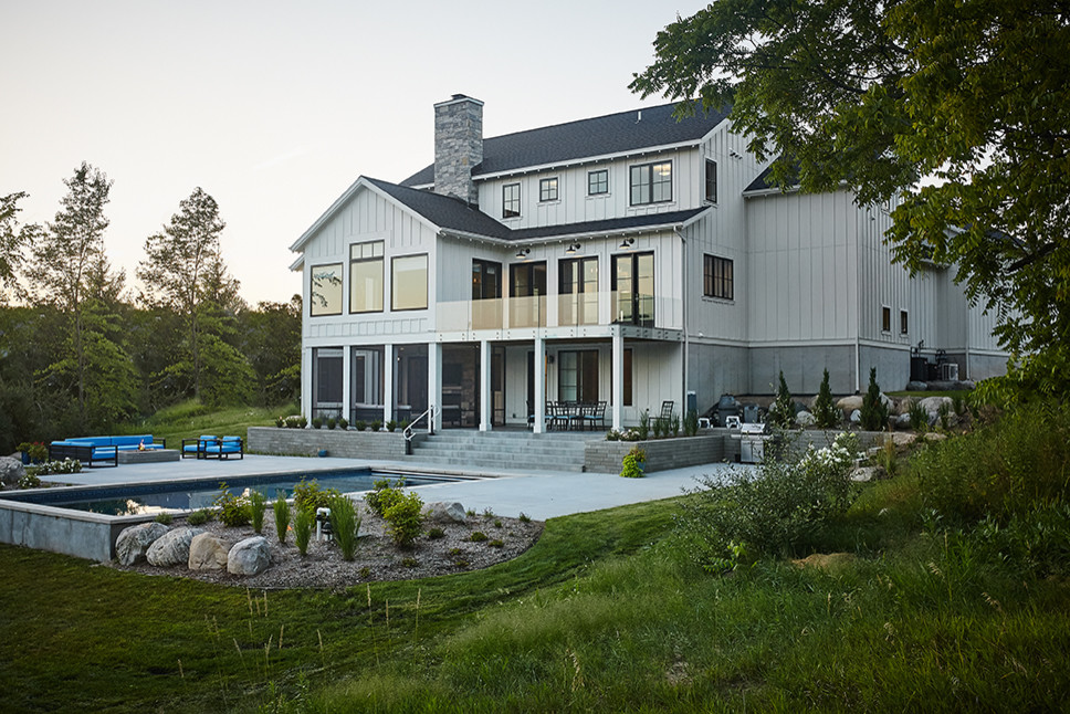 Diseño de fachada blanca de estilo de casa de campo grande de dos plantas con revestimiento de aglomerado de cemento y tejado a dos aguas