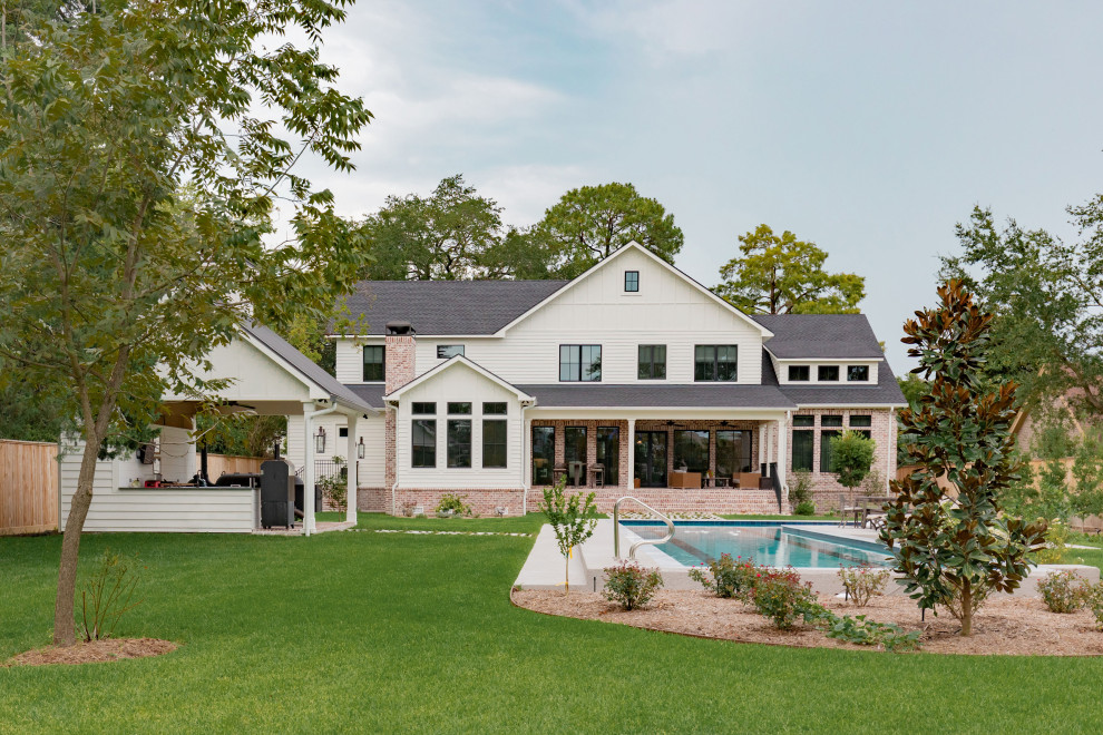 Großes, Zweistöckiges Country Einfamilienhaus mit Mix-Fassade, weißer Fassadenfarbe, Satteldach und Schindeldach in Houston