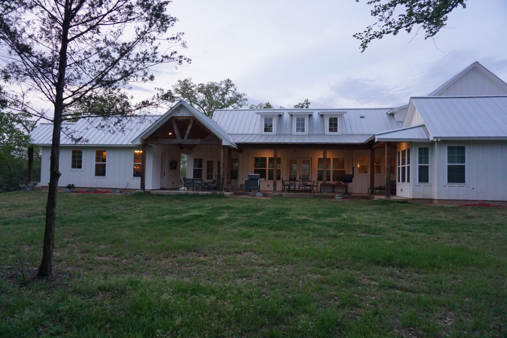 Zweistöckiges Landhausstil Einfamilienhaus mit weißer Fassadenfarbe und Blechdach in Houston