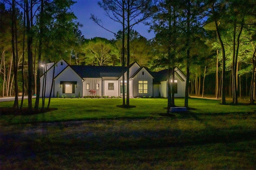 Esempio della villa piccola bianca country a un piano con rivestimenti misti, tetto a capanna e copertura mista