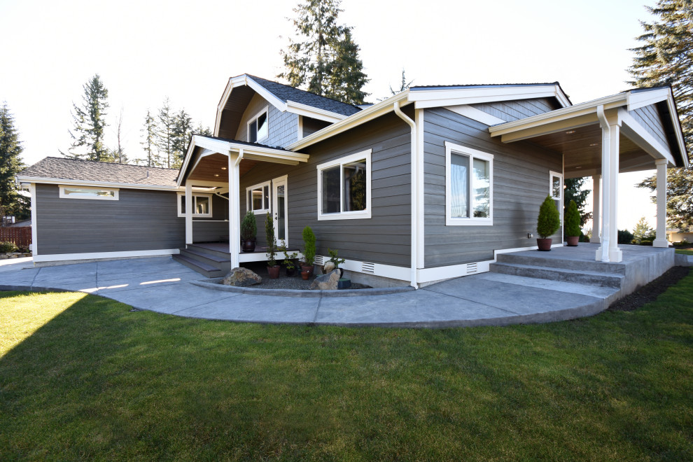 Großes, Zweistöckiges Landhausstil Haus mit grauer Fassadenfarbe, Mansardendach und Schindeldach in Seattle