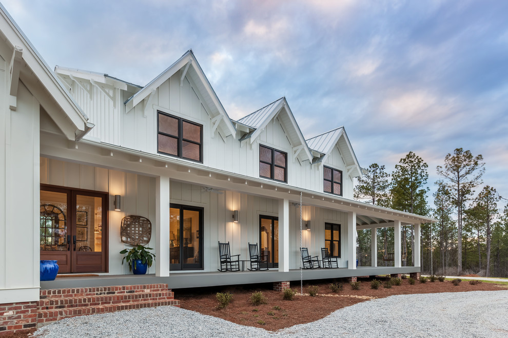 Großes, Zweistöckiges Landhausstil Einfamilienhaus mit Mix-Fassade, weißer Fassadenfarbe und Blechdach in Sonstige