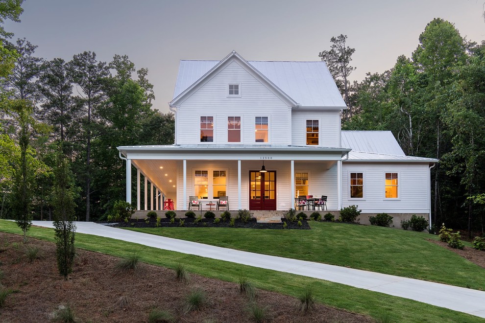 Ispirazione per la facciata di una casa bianca country a due piani con rivestimenti misti e copertura in metallo o lamiera