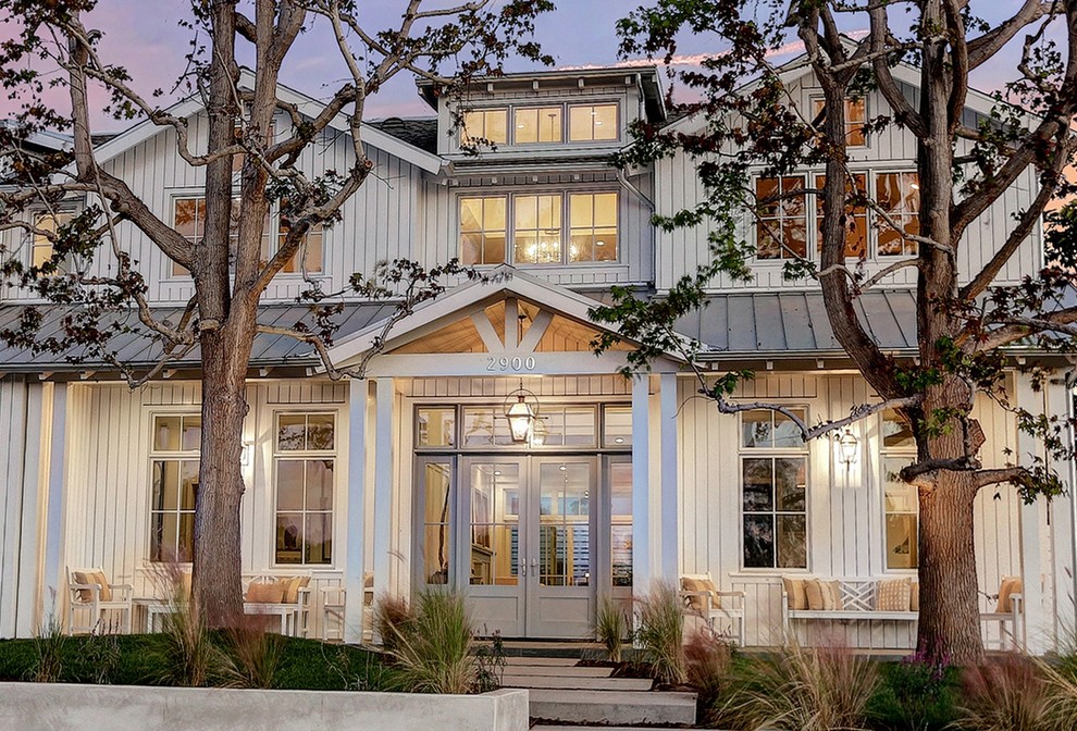 Großes, Zweistöckiges Landhausstil Haus mit Vinylfassade, weißer Fassadenfarbe und Satteldach in Los Angeles