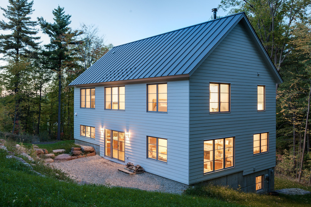 This is an example of a medium sized and gey rural two floor detached house in Burlington with vinyl cladding, a pitched roof and a metal roof.