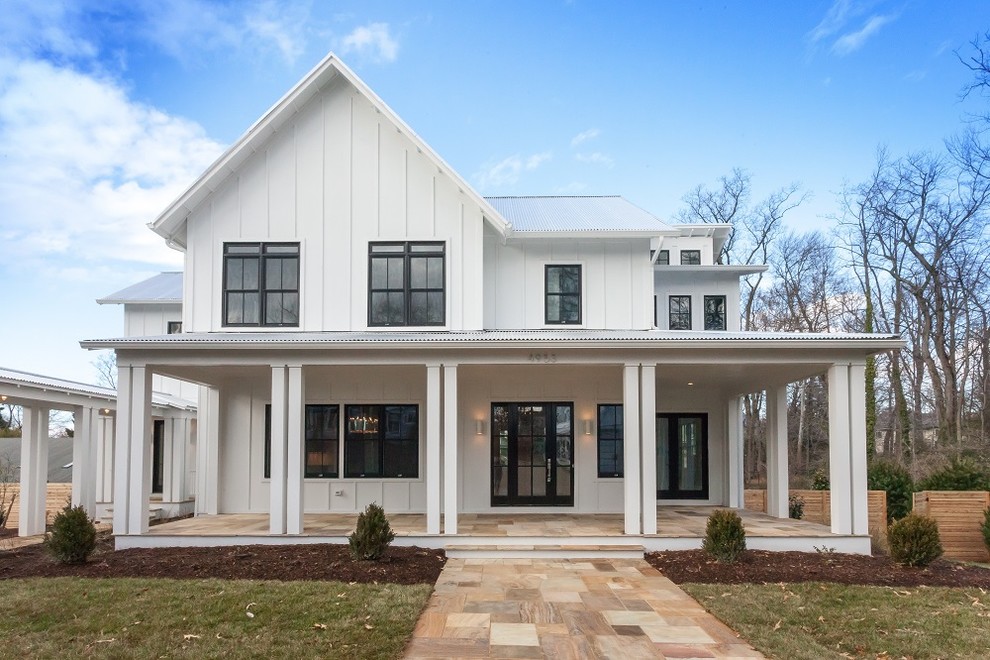 Country white three-story house exterior idea in DC Metro with a metal roof