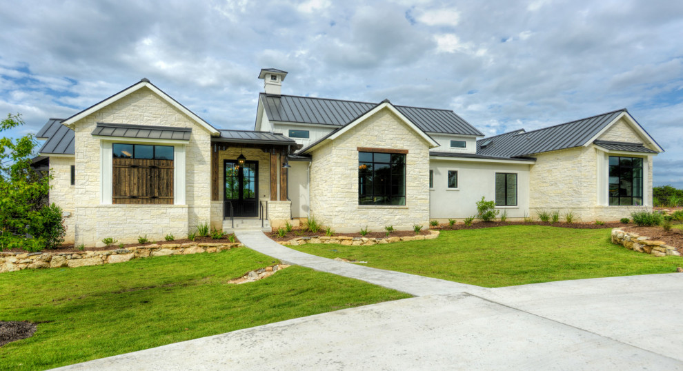 Idee per la facciata di una casa bianca country a un piano di medie dimensioni con rivestimento in pietra e copertura in metallo o lamiera