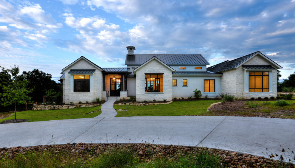 Стильный дизайн: одноэтажный, белый частный загородный дом среднего размера в стиле кантри с облицовкой из камня, односкатной крышей и металлической крышей - последний тренд