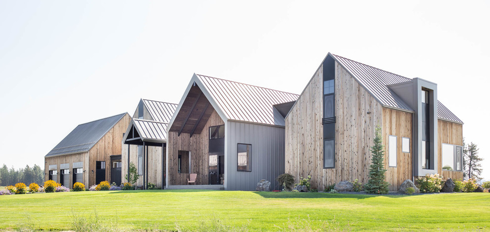 Inspiration pour une grande façade de maison marron design en bois à deux étages et plus avec un toit à deux pans et un toit en métal.