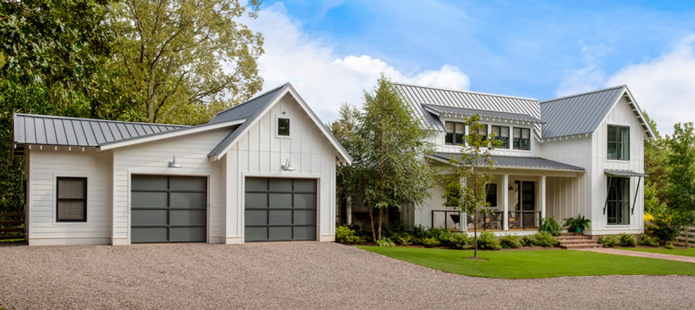 Foto della villa grande bianca country a due piani con rivestimento in legno, tetto a padiglione e copertura in metallo o lamiera