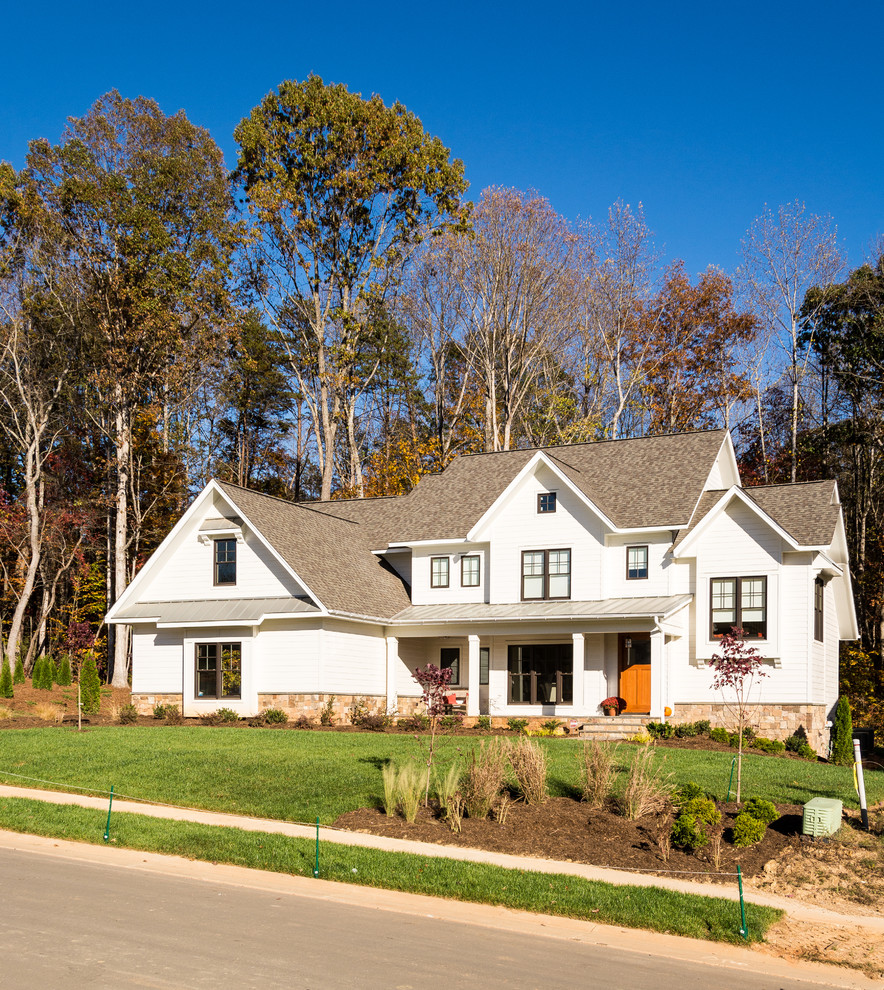 Immagine della facciata di una casa bianca country a due piani di medie dimensioni con rivestimenti misti