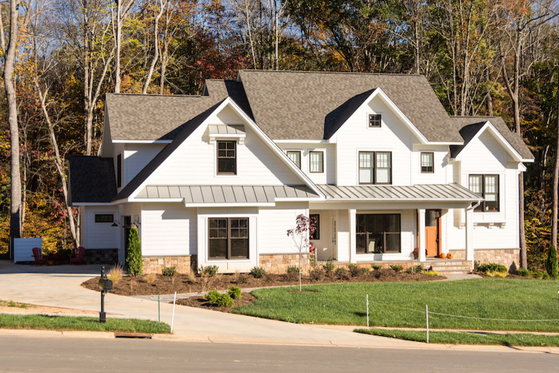 Foto della facciata di una casa bianca country a due piani di medie dimensioni con rivestimenti misti