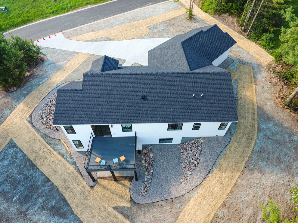Modelo de fachada de casa blanca de estilo de casa de campo de tamaño medio de dos plantas con revestimiento de madera, tejado a dos aguas y tejado de teja de madera