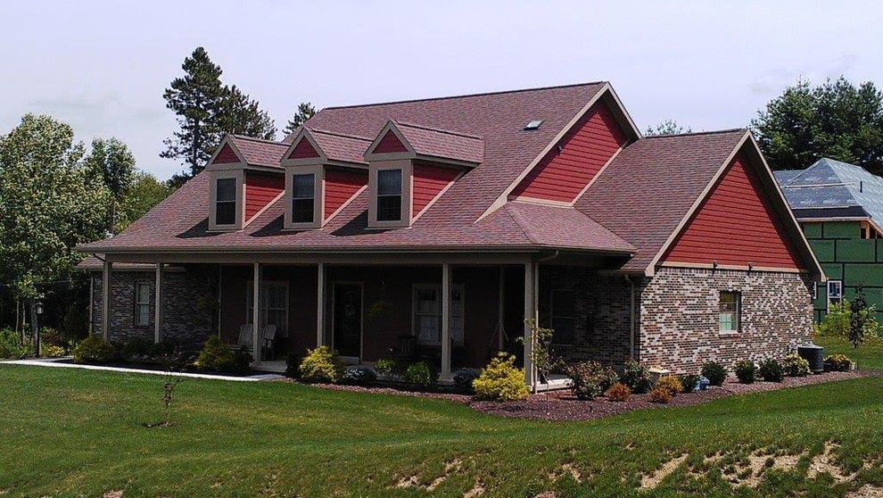 Lantlig inredning av ett mellanstort rött hus, med blandad fasad